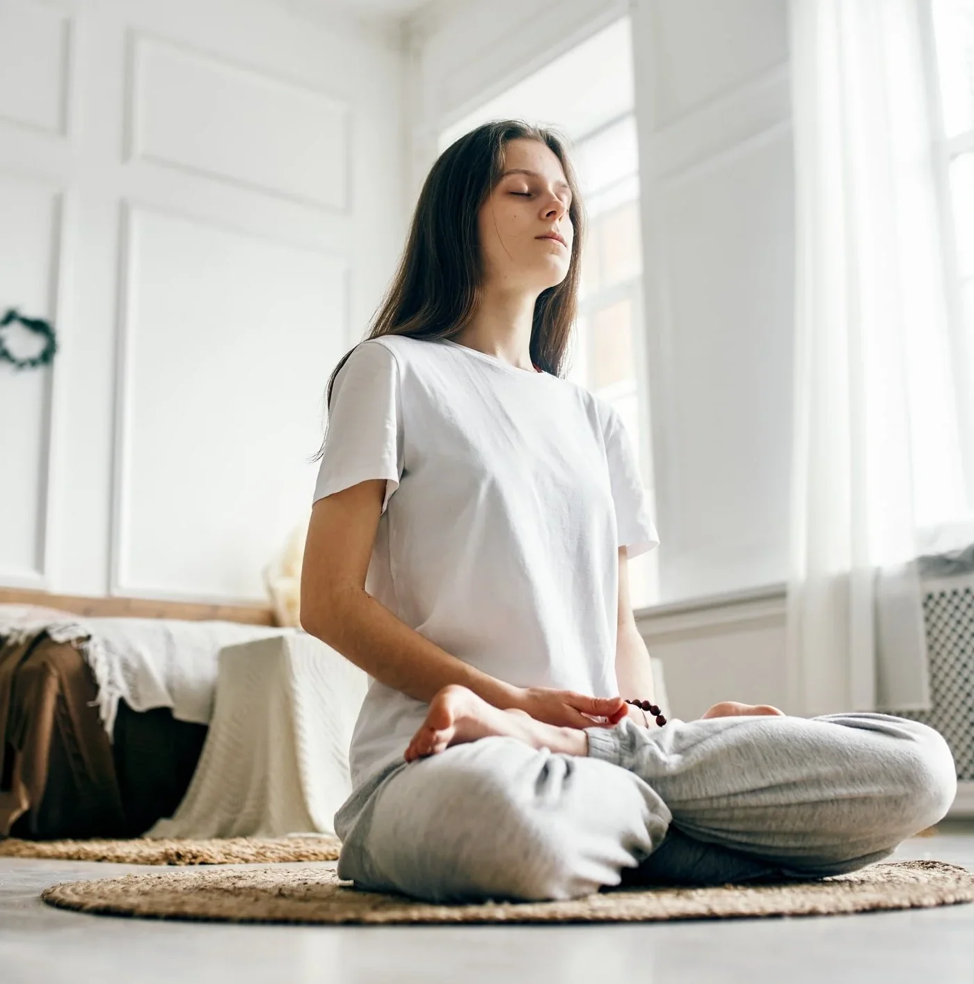 Woman sitting peacefully on the floor meditating, finding calm and relief through OCD therapy and ERP treatment thruough Wellness Counseling PLLC. in Winston-Salem, NC