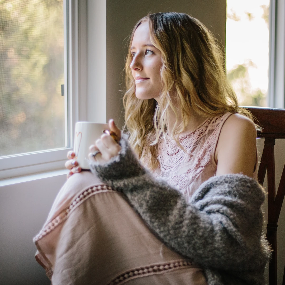 icbt-ocd-therapy-nc Woman sitting quietly by a window in soft light, a calm image for I-CBT therapy for OCD with Wellness Counseling Pllc